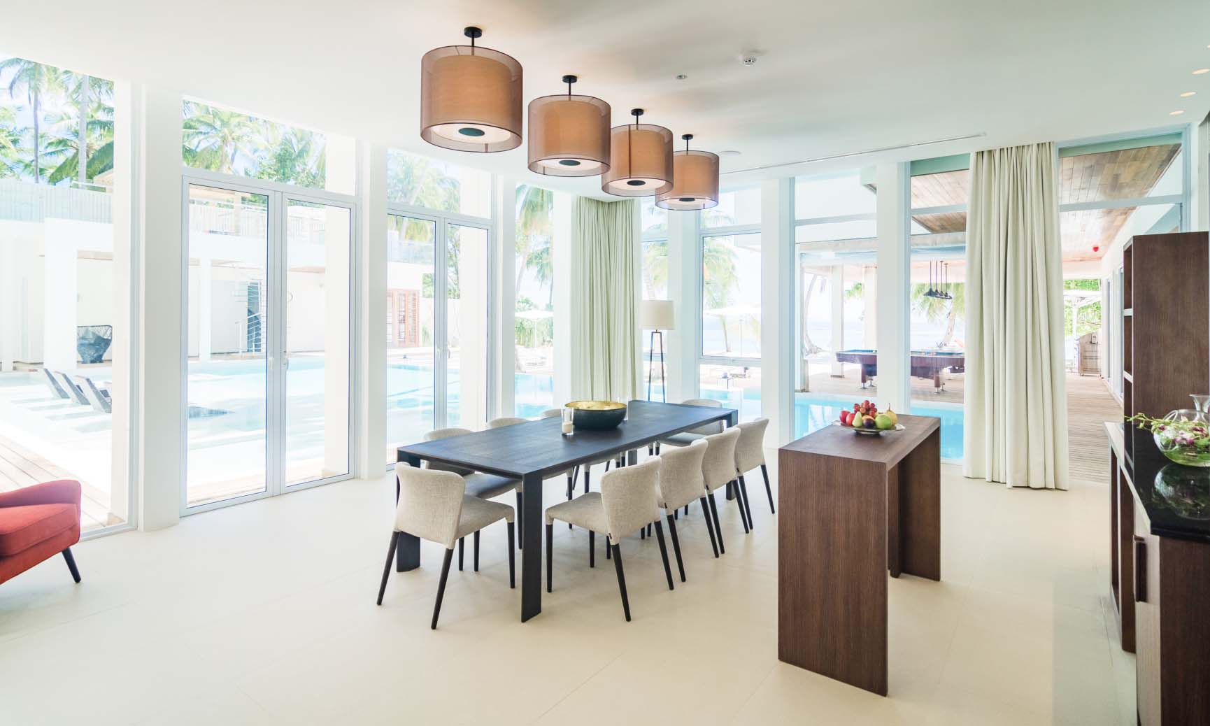 The expansive dining area open with floor to ceiling windows at the Amilla Estate, our Maldives Mansion.