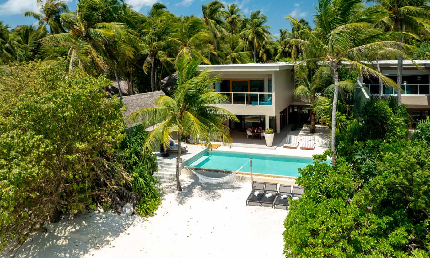 An exterior view of the freshwater pool and beach hammock at our private beachfront Family Residences and Villas.