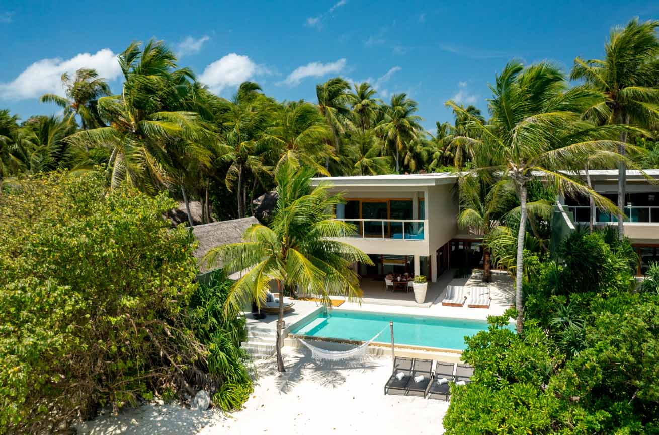 An exterior view of the freshwater pool and beach hammock at our private beachfront Family Residences and Villas.