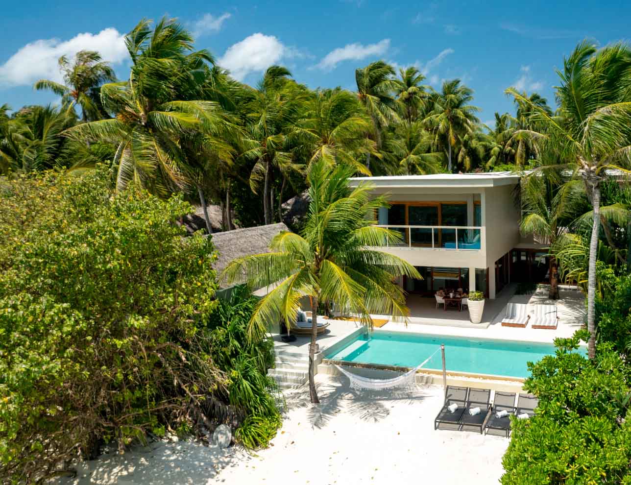 An exterior view of the freshwater pool and beach hammock at our private beachfront Family Residences and Villas.